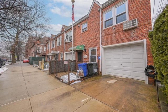 exterior space featuring a garage and a wall mounted AC