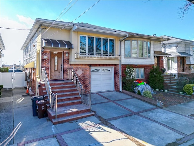 view of front of property featuring fence, stucco siding, concrete driveway, a garage, and brick siding