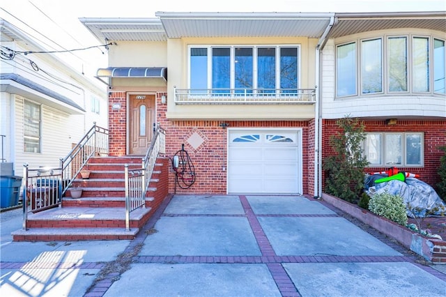 view of front of home featuring a garage, driveway, brick siding, and a balcony