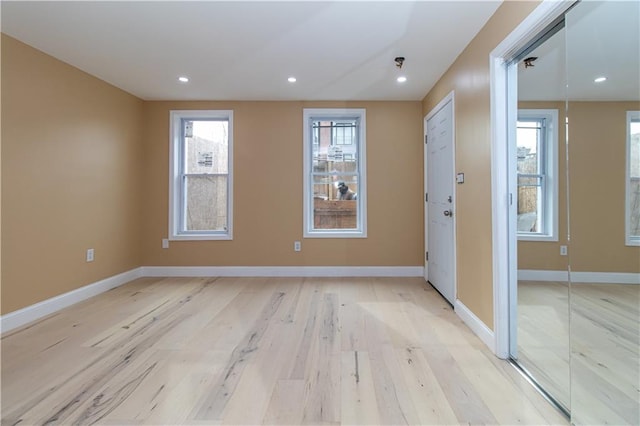 spare room with recessed lighting, baseboards, and light wood-type flooring