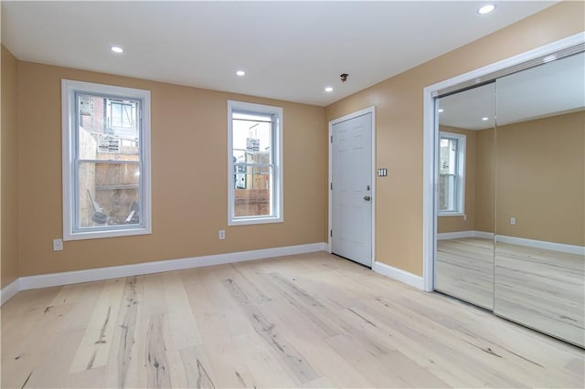 empty room with recessed lighting, baseboards, and light wood-type flooring