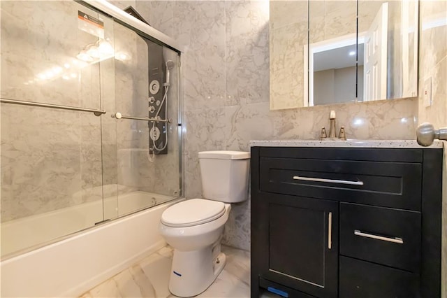 full bath featuring marble finish floor, toilet, vanity, and shower / bath combination with glass door