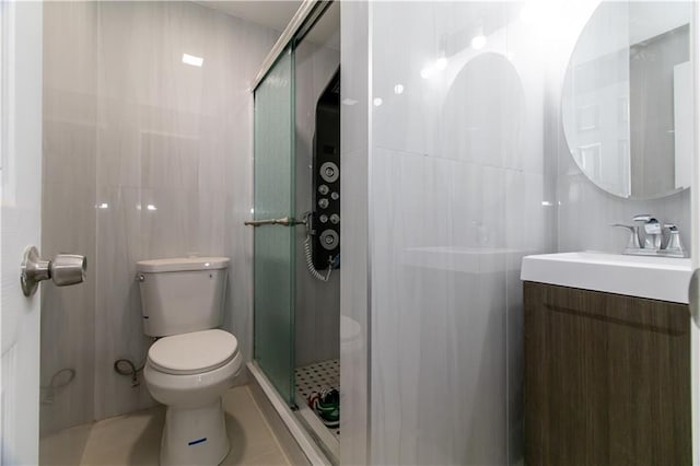 full bathroom with vanity, a stall shower, tile patterned flooring, tile walls, and toilet