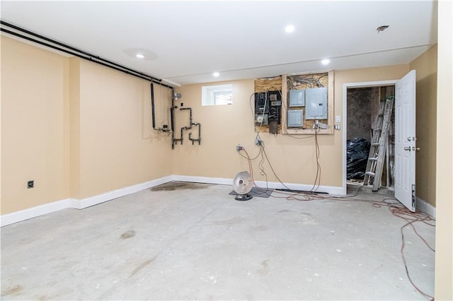 basement featuring electric panel, baseboards, and recessed lighting