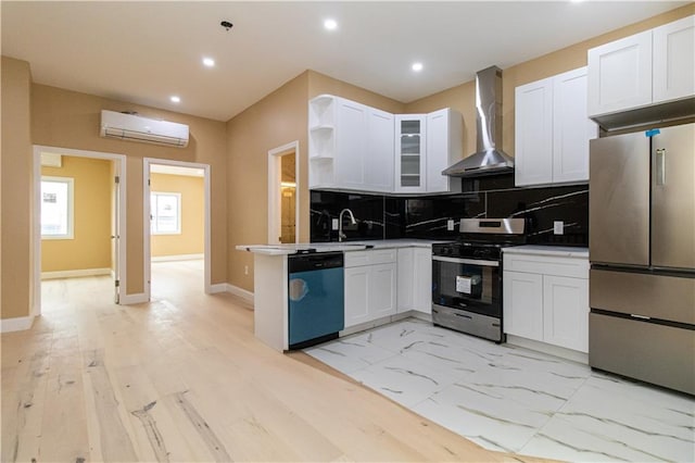 kitchen featuring a wall mounted AC, backsplash, stainless steel appliances, wall chimney exhaust hood, and white cabinets