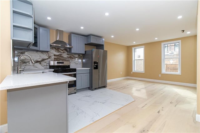 kitchen featuring a sink, tasteful backsplash, recessed lighting, appliances with stainless steel finishes, and wall chimney range hood