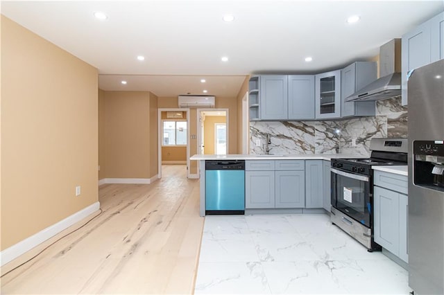 kitchen featuring tasteful backsplash, recessed lighting, stainless steel appliances, wall chimney exhaust hood, and light countertops