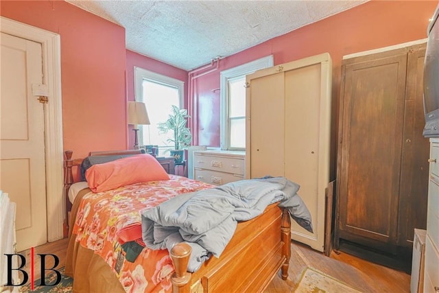 bedroom featuring light wood finished floors and a textured ceiling