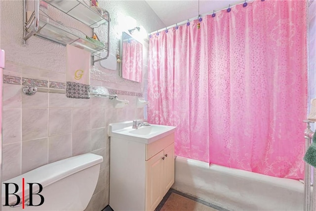 bathroom with toilet, tile walls, vanity, and shower / bath combination with curtain