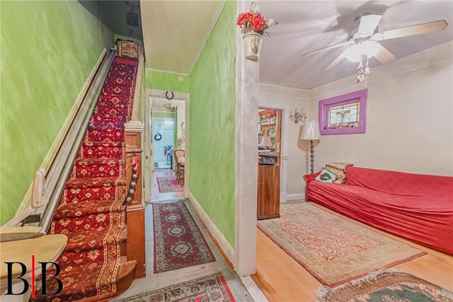 bedroom with wood finished floors, ornamental molding, and a ceiling fan