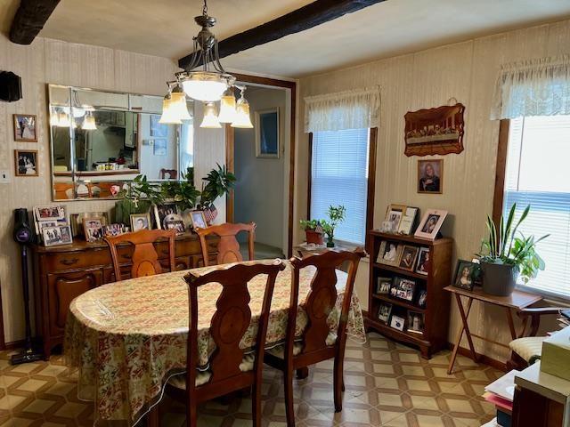 dining area featuring beamed ceiling