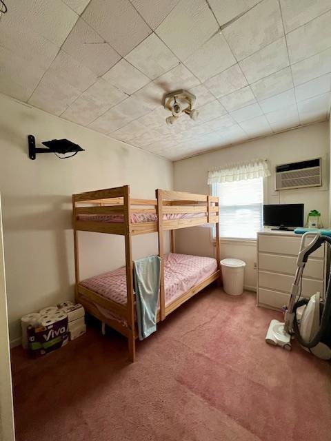 carpeted bedroom with a wall mounted AC