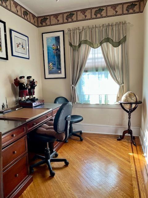 home office with light hardwood / wood-style flooring