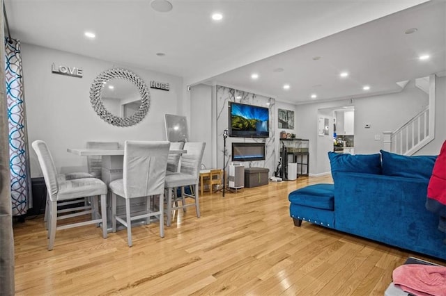 living room featuring crown molding and light hardwood / wood-style flooring