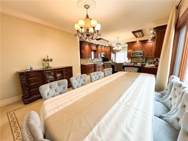 dining room featuring ornamental molding, sink, light tile patterned floors, and a notable chandelier