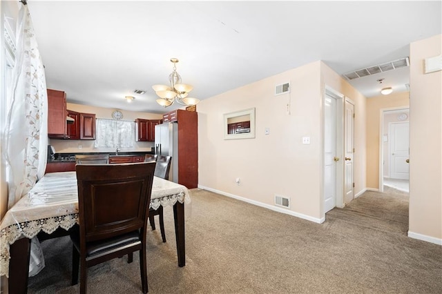 carpeted dining area featuring a chandelier