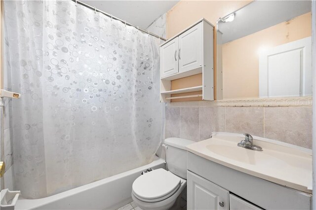 full bathroom featuring tile walls, vanity, toilet, and shower / tub combo with curtain