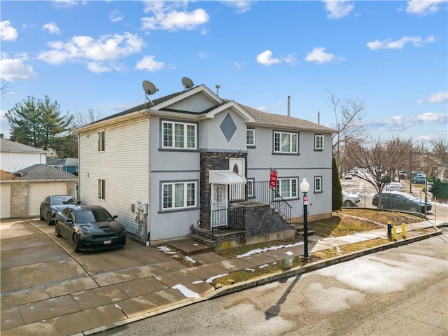 view of front of house featuring a garage, an outdoor structure, and stucco siding