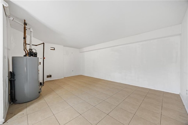 basement with water heater and light tile patterned floors