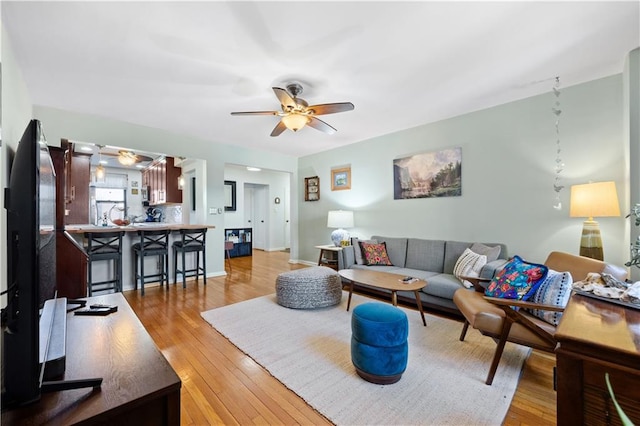 living room with ceiling fan and light hardwood / wood-style floors