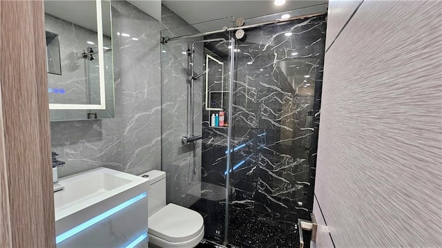 bathroom with vanity, tile walls, an enclosed shower, and toilet