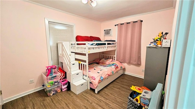 bedroom featuring dark hardwood / wood-style flooring, ornamental molding, and an AC wall unit