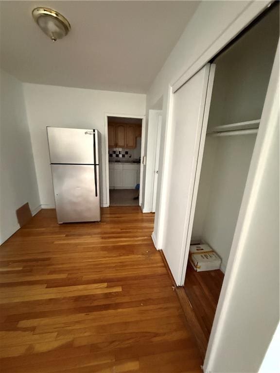 hallway with light hardwood / wood-style floors