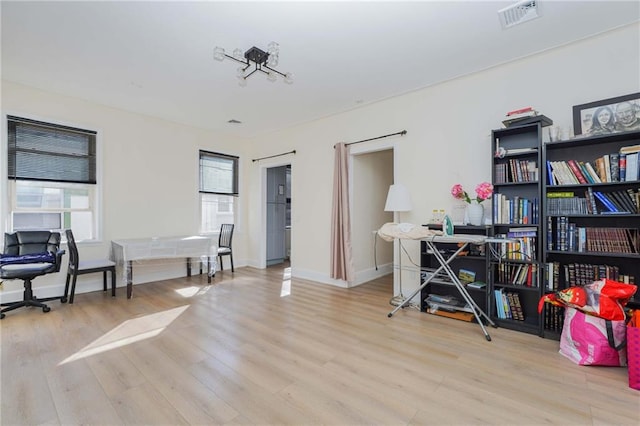 office area featuring visible vents, light wood-style flooring, and baseboards