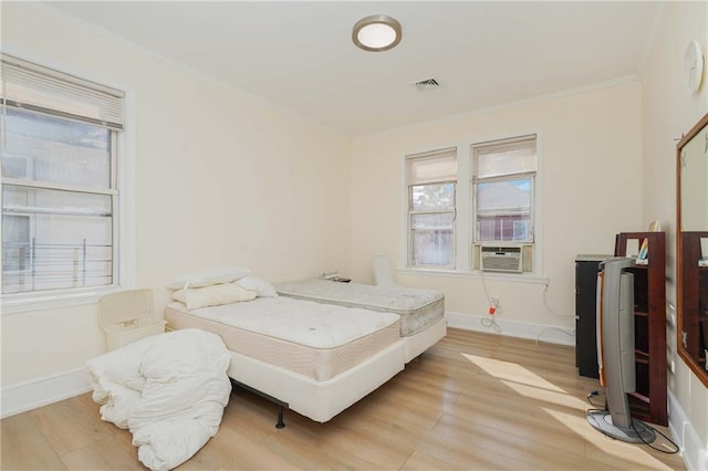 bedroom featuring light wood-style floors, multiple windows, and baseboards