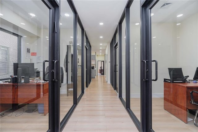 hall with light wood-style floors, recessed lighting, visible vents, and baseboards