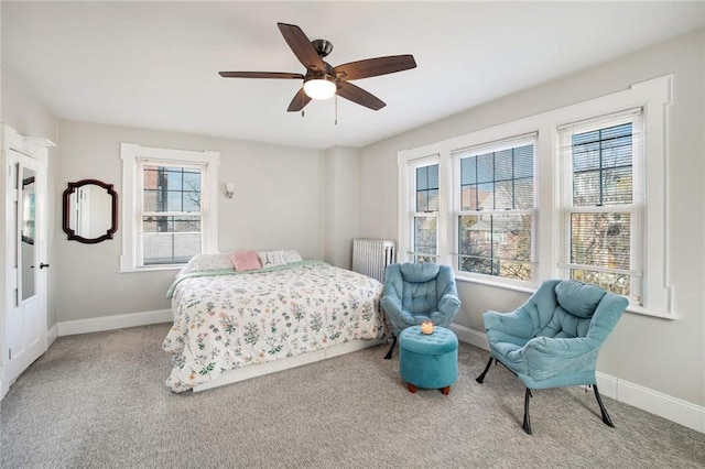 bedroom with ceiling fan, light colored carpet, and radiator heating unit