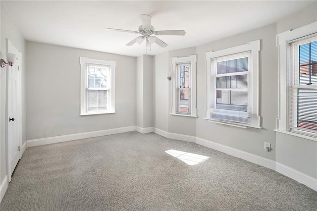 carpeted empty room with plenty of natural light and ceiling fan