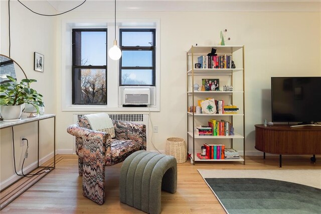 living area with cooling unit and wood-type flooring