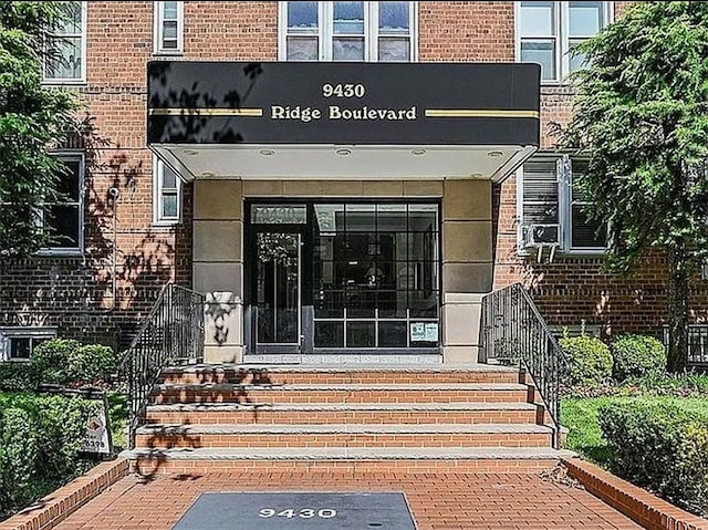 view of exterior entry featuring brick siding