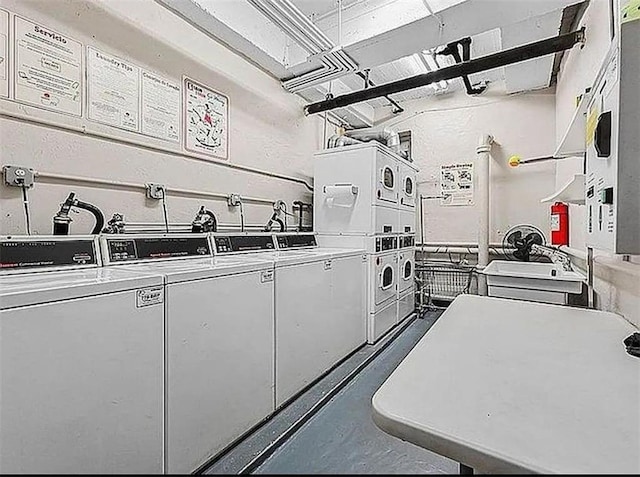 kitchen with stacked washer / dryer, white cabinets, and independent washer and dryer