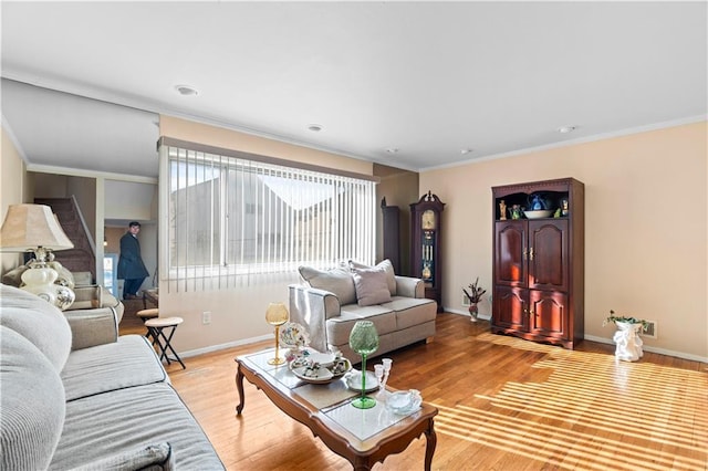 living room with ornamental molding and light hardwood / wood-style floors