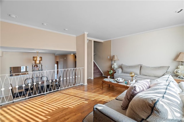 living area featuring a chandelier, crown molding, and wood finished floors