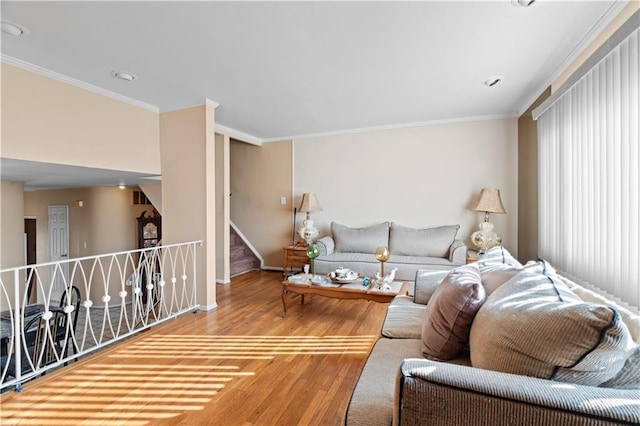 living area with stairway, crown molding, baseboards, and wood finished floors