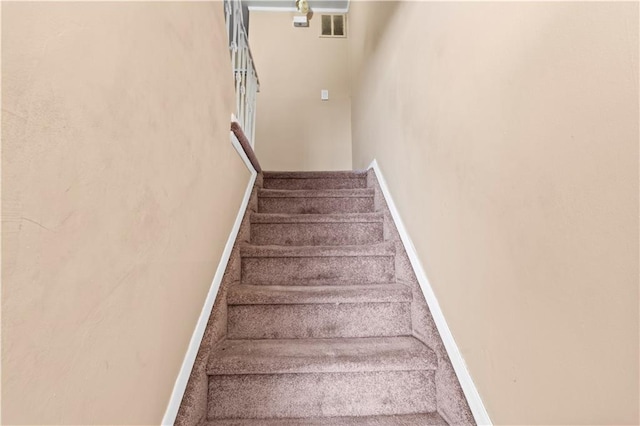 staircase with baseboards and visible vents