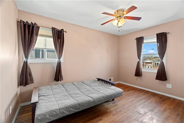 bedroom with baseboards, wood-type flooring, and ceiling fan