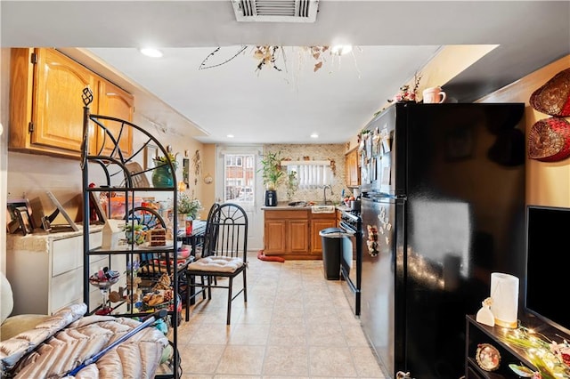 kitchen with visible vents, light countertops, recessed lighting, black appliances, and a sink