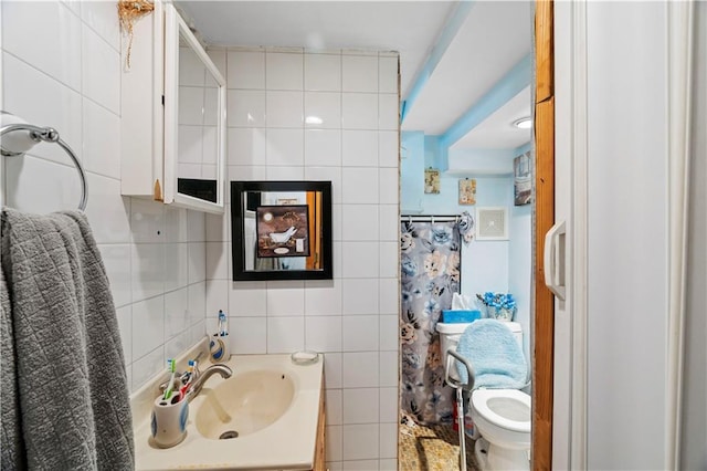 full bathroom with vanity, tile walls, toilet, and tasteful backsplash