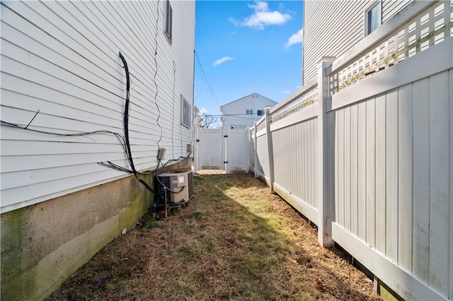 view of yard with a gate, cooling unit, and fence