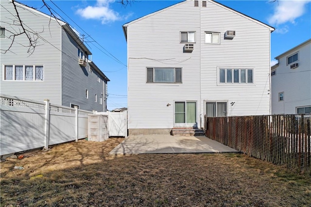 back of property with a yard, entry steps, a patio, and a fenced backyard