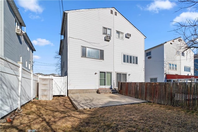 rear view of property with a gate, entry steps, a fenced backyard, and a patio area