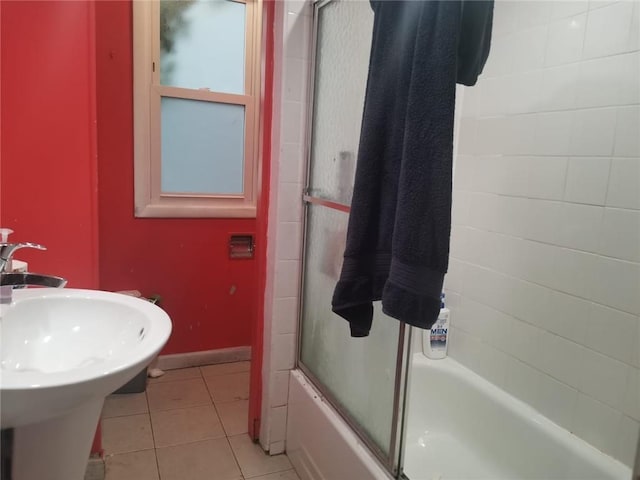 bathroom featuring tile patterned flooring, sink, and enclosed tub / shower combo