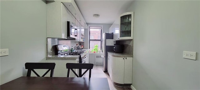 kitchen featuring backsplash, stainless steel appliances, and white cabinets