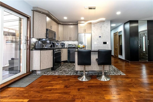 kitchen with pendant lighting, dark countertops, dark wood-type flooring, modern cabinets, and black appliances