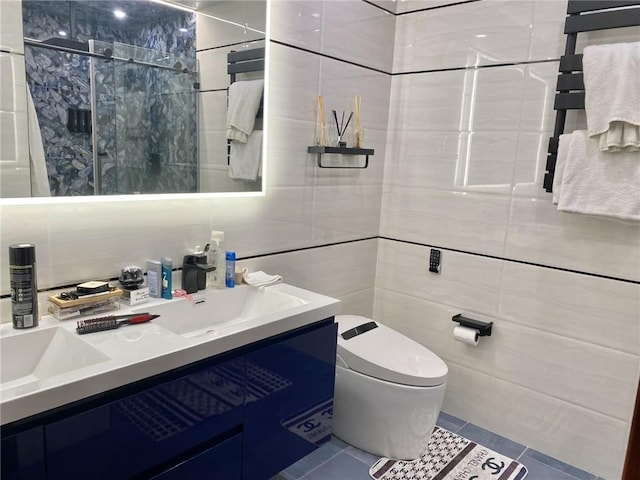 bathroom featuring tile patterned floors, vanity, toilet, and tile walls