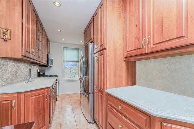 kitchen with tasteful backsplash, stainless steel appliances, and light tile patterned flooring